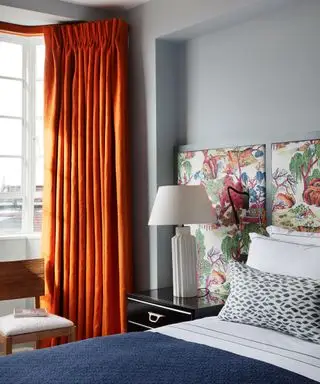 Chambre grise avec rideaux orange et linge de lit bleu