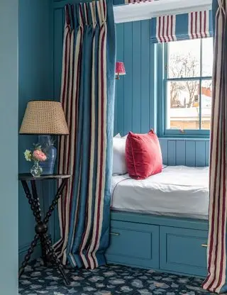 Chambre bleue avec lit intégré et murs bleus avec des accents rouges