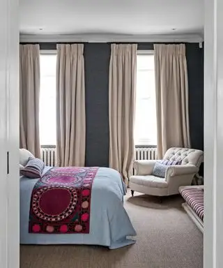 chambre avec murs gris foncé, rideaux neutres et jeté de lit coloré