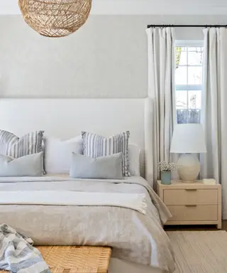 Et hvidt soveværelse med blå og flettede accenter.