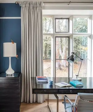 Ideas de cortinas de ventana grandes con cortinas grises en un estudio azul con escritorio negro y silla gris