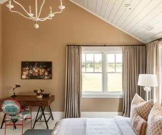 חדר עליית גג עם קירות ניטרליים חמים ושולחן כתיבה בפינה