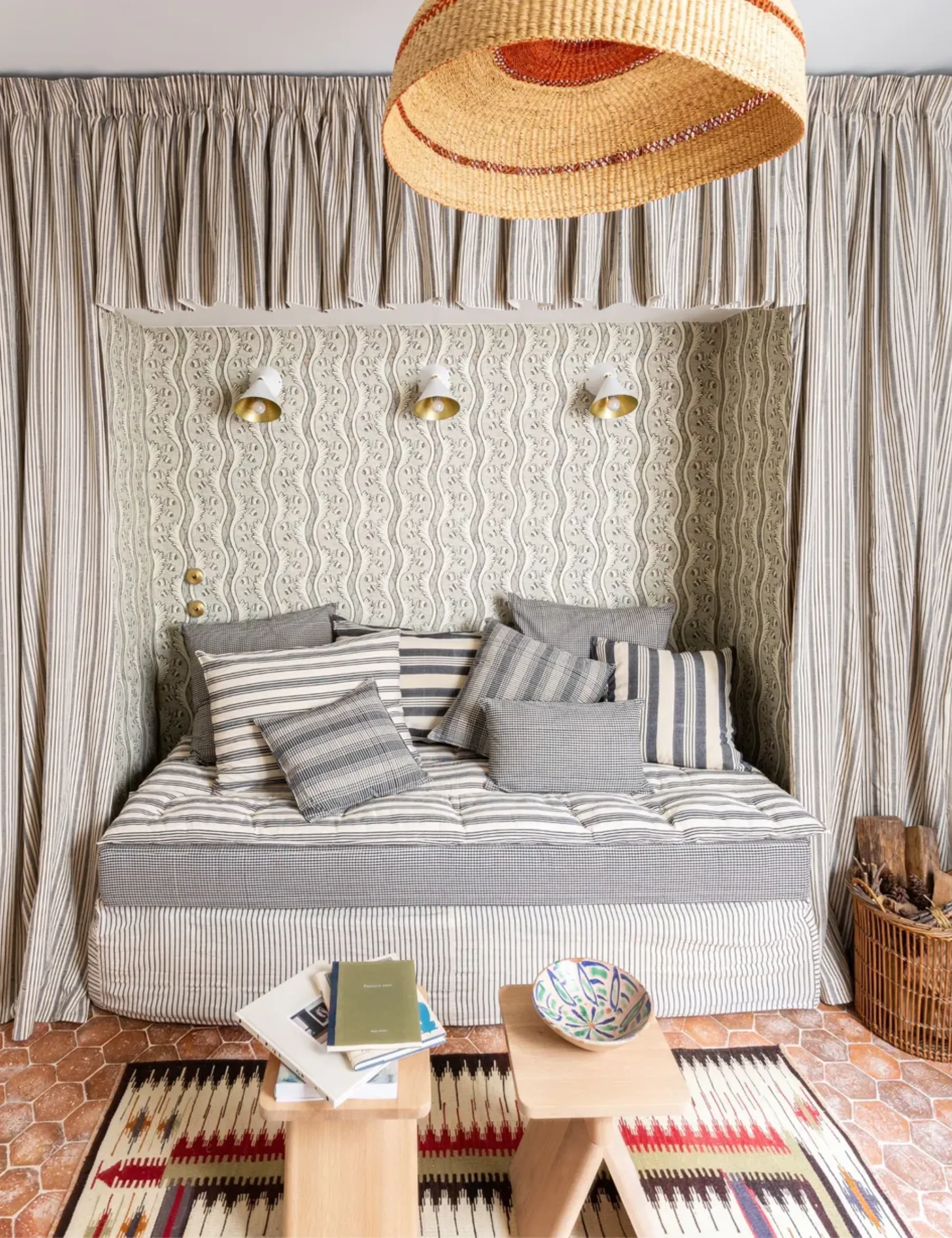 Séjour avec canapé convertible et baldaquin en rotin, carrelage en terre cuite clair et tabourets en bois' loading='lazy' title=