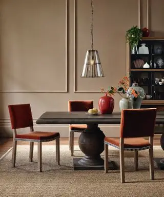 chaises de salle à manger en velours orange dans une salle à manger neutre