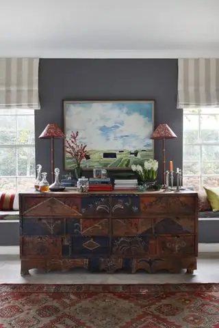 salon avec accents gris, stores à rayures, tapis vintage, console, sièges de fenêtre