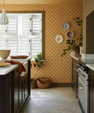Carta da parati giallo senape in una cucina di Little Greene