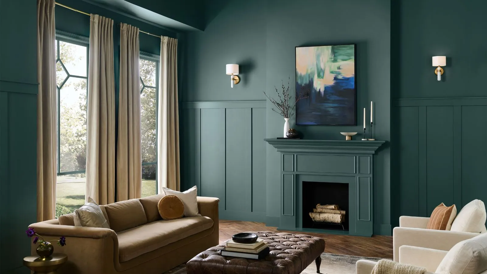 Dyp grønn malt stue med peis store vinduer beige sofa skinn ottoman og krem ​​lenestoler' loading='lazy' title=