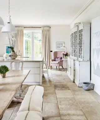 나무 테이블과 벤치 좌석이 있는 흰색 주방