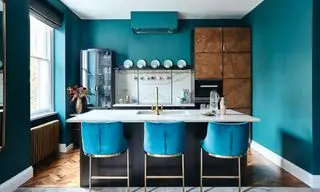 Idées de couleurs de cuisine turquoise avec des murs clairs, des tabourets de bar et des comptoirs blancs.