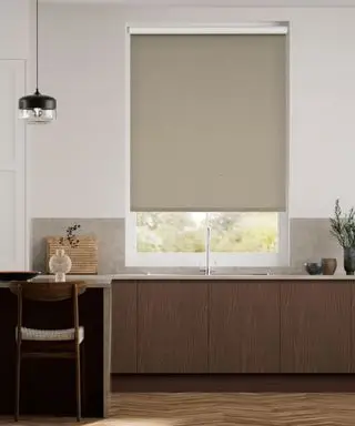 Cuisine moderne marron avec armoires de cuisine en bois foncé, îlot de cuisine avec sièges, parquet, murs peints en blanc, store enrouleur marron