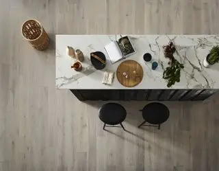 Vue aérienne du parquet de cuisine en bois d'ingénierie gris pâle sous un bar de petit-déjeuner en marbre.