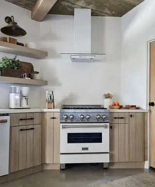 Kuchnia Julii Dempster Pallisades z drewnianymi szafkami i gipsowymi ścianami fotografuje Jennę Peffley