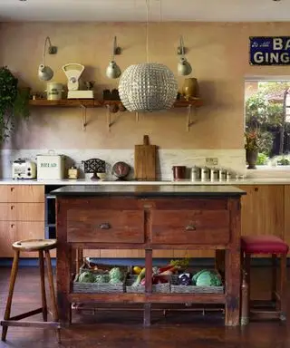 Nowoczesna rustykalna kuchnia marki Pluck z nowymi szafkami i zabytkową wyspą na centralnym stole