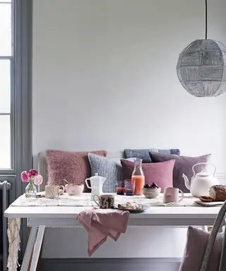 Photos d'une cuisine avec une table de petit-déjeuner et des sièges avec un grand choix de coussins colorés.