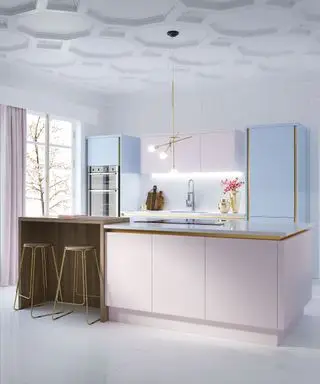 Un exemple d'idées d'éclairage de cuisine moderne montrant une cuisine dans des tons de rose pastel et de bleu avec une bordure dorée.
