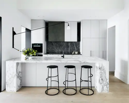 Idées d'éclairage de cuisine avec un luminaire à abat-jour en miroir sur un îlot bleu sarcelle avec des armoires à façade en verre