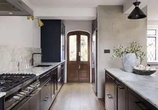 Cuisine longue et étroite en bois sombre avec plan de travail blanc