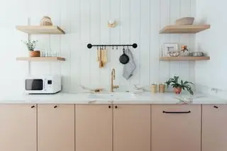 Cuisine de style cottage pêche moderne avec étagères en bois et murs à feuillures blancs