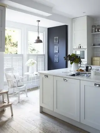 Idées de cuisine blanche avec des armoires peintes, un dosseret et des volets carrelés blancs, ainsi qu'un tableau noir peint.