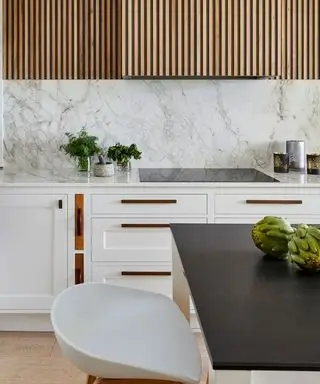 Cuisine blanche avec armoires en bois et dosseret en marbre