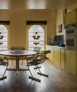cuisine jaune avec plafond brillant et vitraux avec accessoires chromés