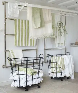 Jak uspořádat prádelnu s nástěnnými sušáky v bílém schématu se světle zelenými akcenty.