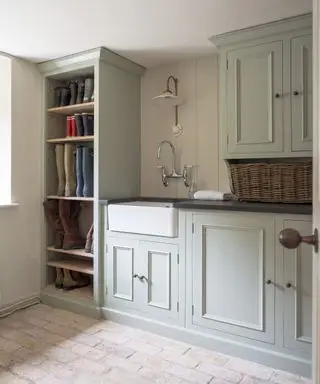 Idee per la lavanderia ispirate al Mudroom con uno scaffale dal pavimento al soffitto pieno di stivali e mobili verniciati di grigio chiaro.