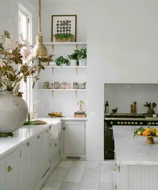 מטבח אפור בהיר עם כיריים שחורות ומשטחי שיש