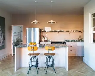 מטבח ורוד מודרני עם אי ושרפרפים תעשייתיים