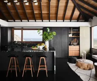 Cuisine de mauvaise humeur avec un îlot de cuisine noir surmonté de marbre noir et blanc