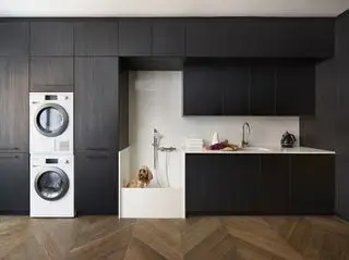 Buanderie moderne avec douche pour chien de Design sSpace London. Les armoires sont en bois stratifié noir avec une pierre composite pratique effet marbre de Carrare sur la surface de travail.