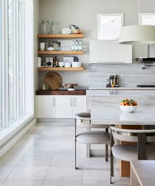 Cuisine moderne avec îlot de cuisine, étagères en bois, table à manger avec sièges