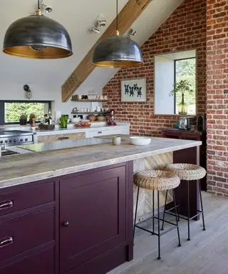 Une cuisine violette avec des plans de travail blancs et un espace repas