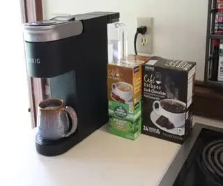 Préparer du café avec la cafetière Keurig K-Supreme SMART, à côté de diverses K-Cups