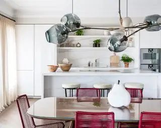 Jednostěnná kuchyně s mramorovým pozadím a červenými židlemi