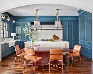 Niebieska nowoczesna kuchnia z drewnianymi szafkami, drewnianą podłogą i przemysłowym stalowym ekstraktorem