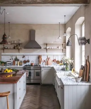 Cocina de estilo rústico con paredes encaladas y muebles pintados.