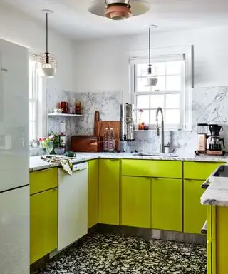 piccola cucina con mobili verde brillante e superfici in marmo