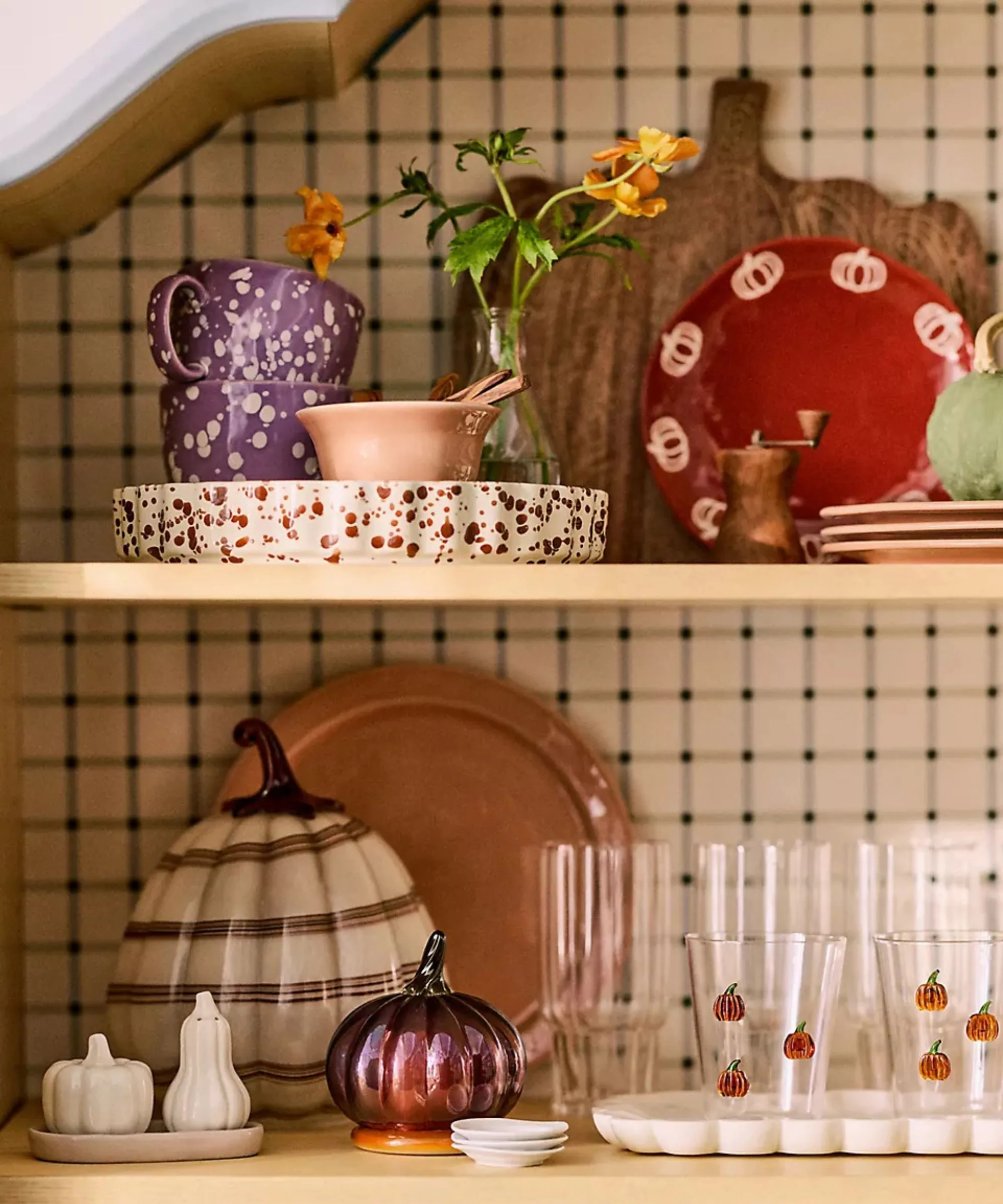 感謝祭のカボチャをテーマにした装飾のガラス製品と食器でスタイルされたキッチンの棚' loading='lazy' title=