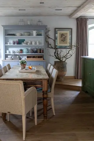 table à manger en chêne récupéré dans la cuisine-salle à manger avec chaises en rotin et commode bleue.webp