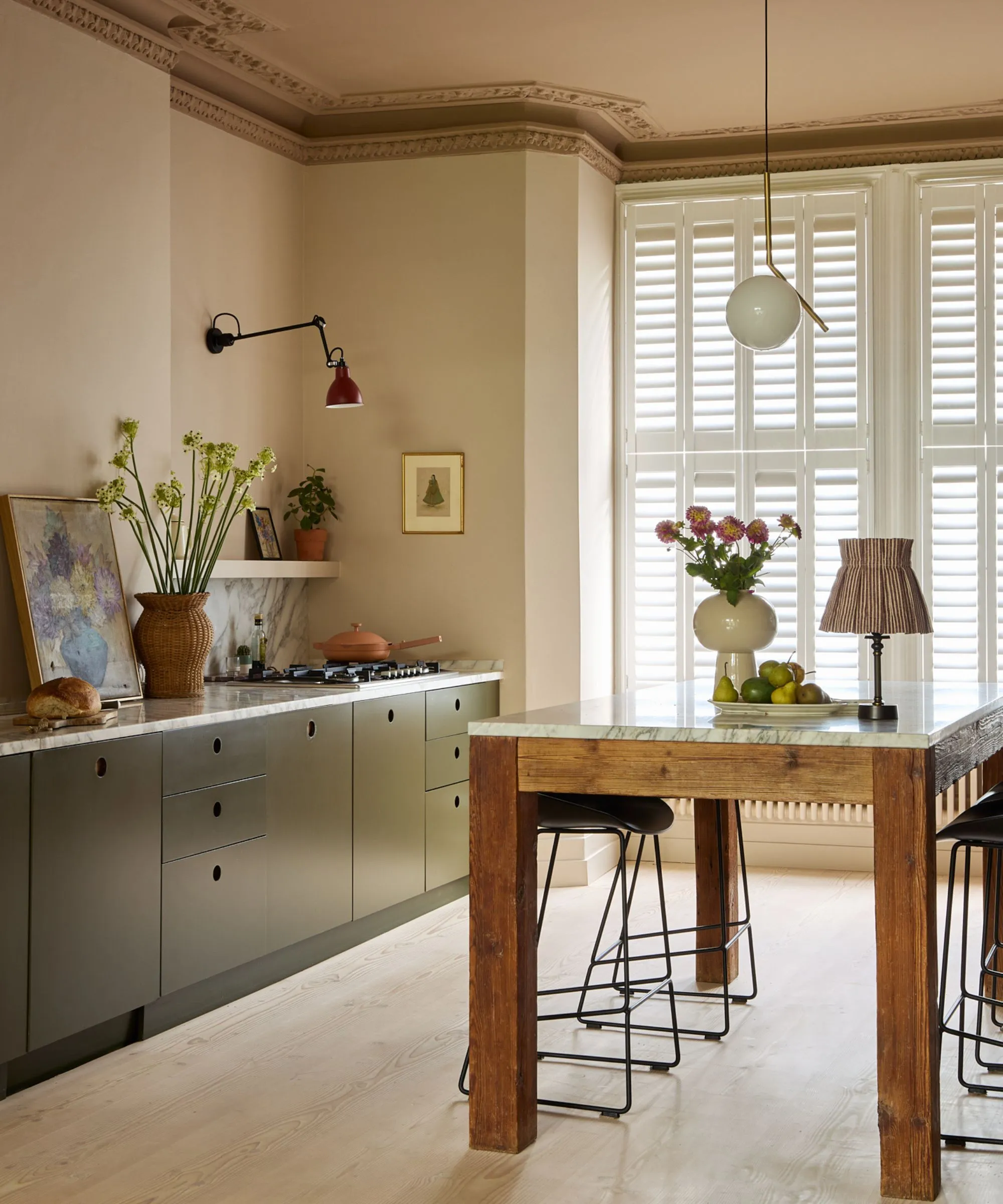 짙은 녹색 캐비닛, 대리석 조리대, 목재 독립형 아일랜드를 갖춘 따뜻한 톤의 주방' loading='lazy' title=