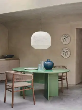 salle à manger moderne avec table circulaire verte et grande lanterne en papier suspendue
