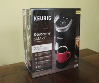 さまざまな K カップの横にある Keurig K-Supreme SMART コーヒー メーカーでコーヒーを作る