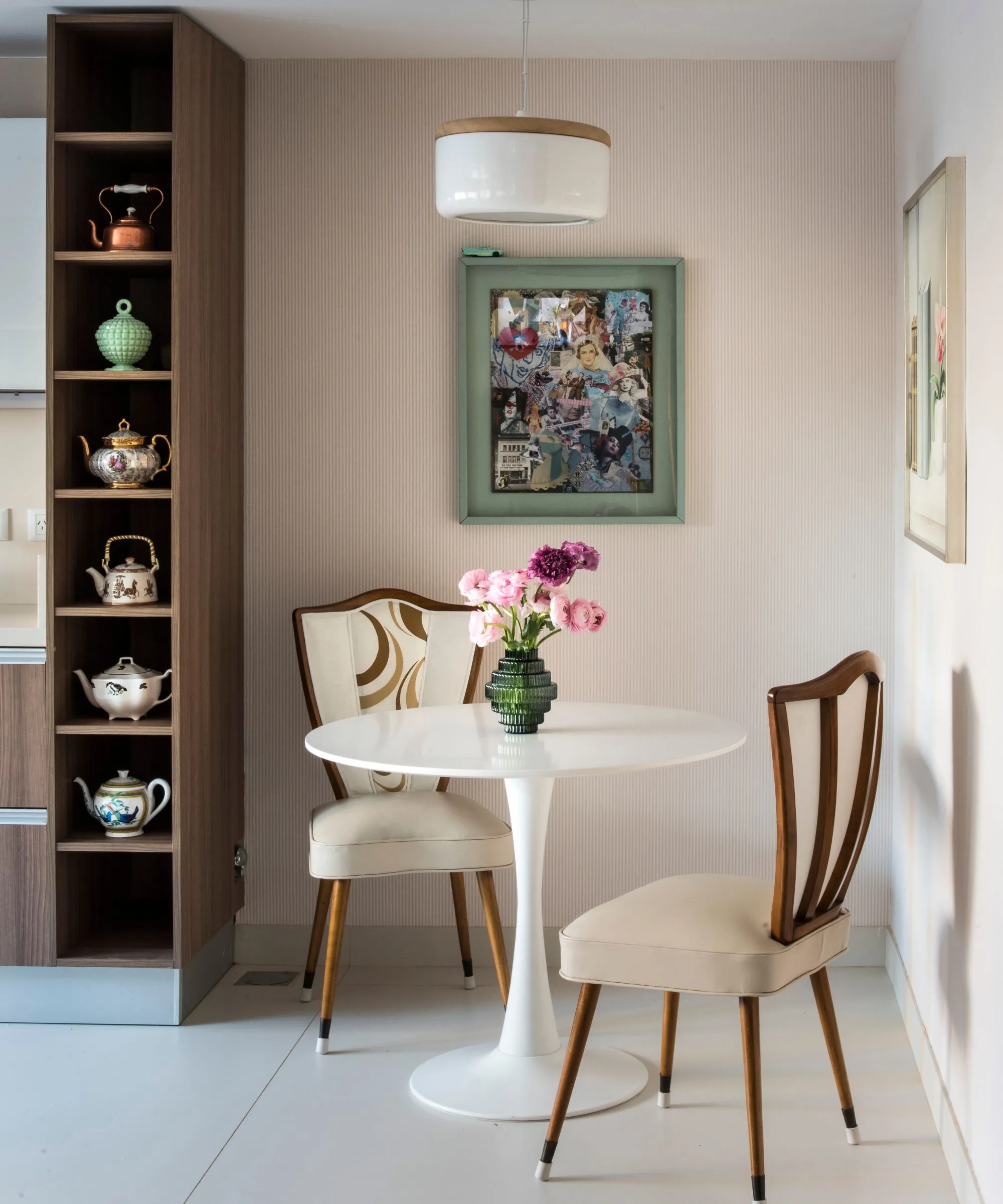 흰색 원형 테이블, 나무 프레임 의자, 분홍색 줄무늬 벽지가 있는 작은 주방 식사 공간' loading='lazy' title=
