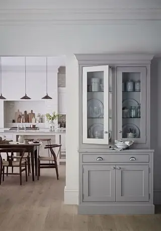 Commode de garde-manger gris avec portes vitrées avec cuisine blanche derrière