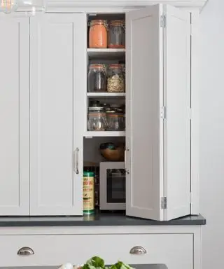 白い食器棚に二つ折りドアを備えた小さな白いキッチンのアイデア