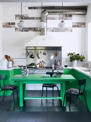 cuisine verte et blanche avec sol peint en noir, table verte, unités peintes en vert et murs blancs