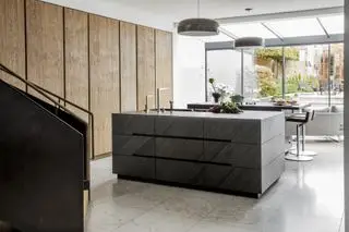 îlots de cuisine doubles noirs, armoires en bois, sol en pierre