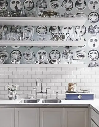 Papier peint à motifs derrière les étagères au-dessus des carreaux blancs.