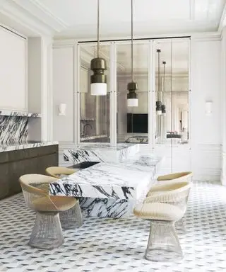 대리석 백스플래시와 테이블을 갖춘 현대적인 흰색 주방